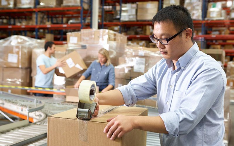 man in warehouse packaging a box