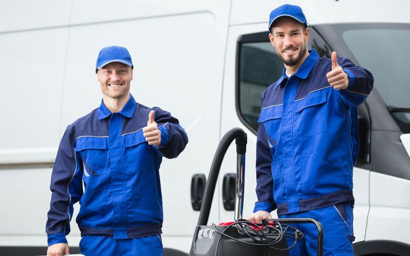 two men outside in full workwear